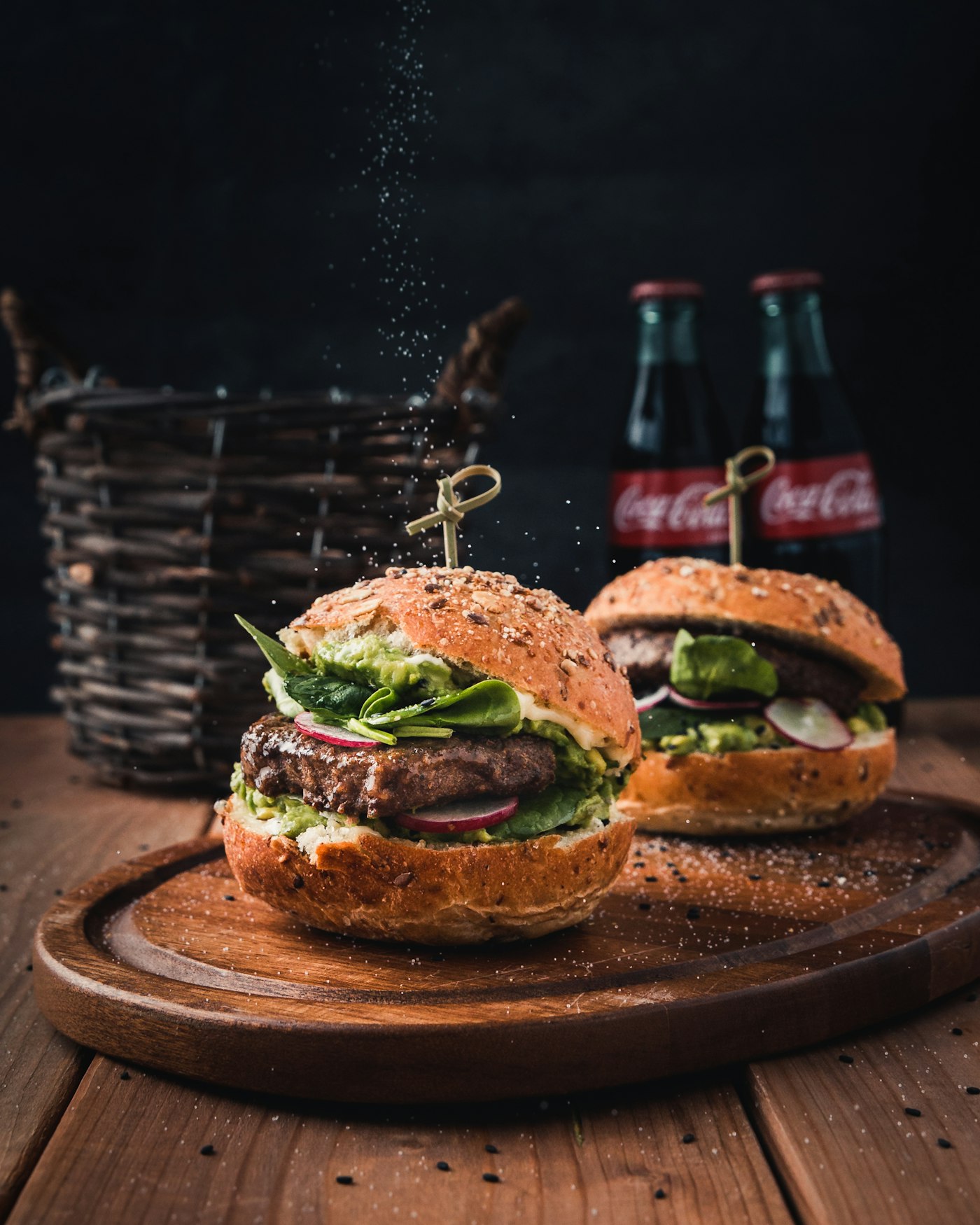 Two burgers with a bottle of cola