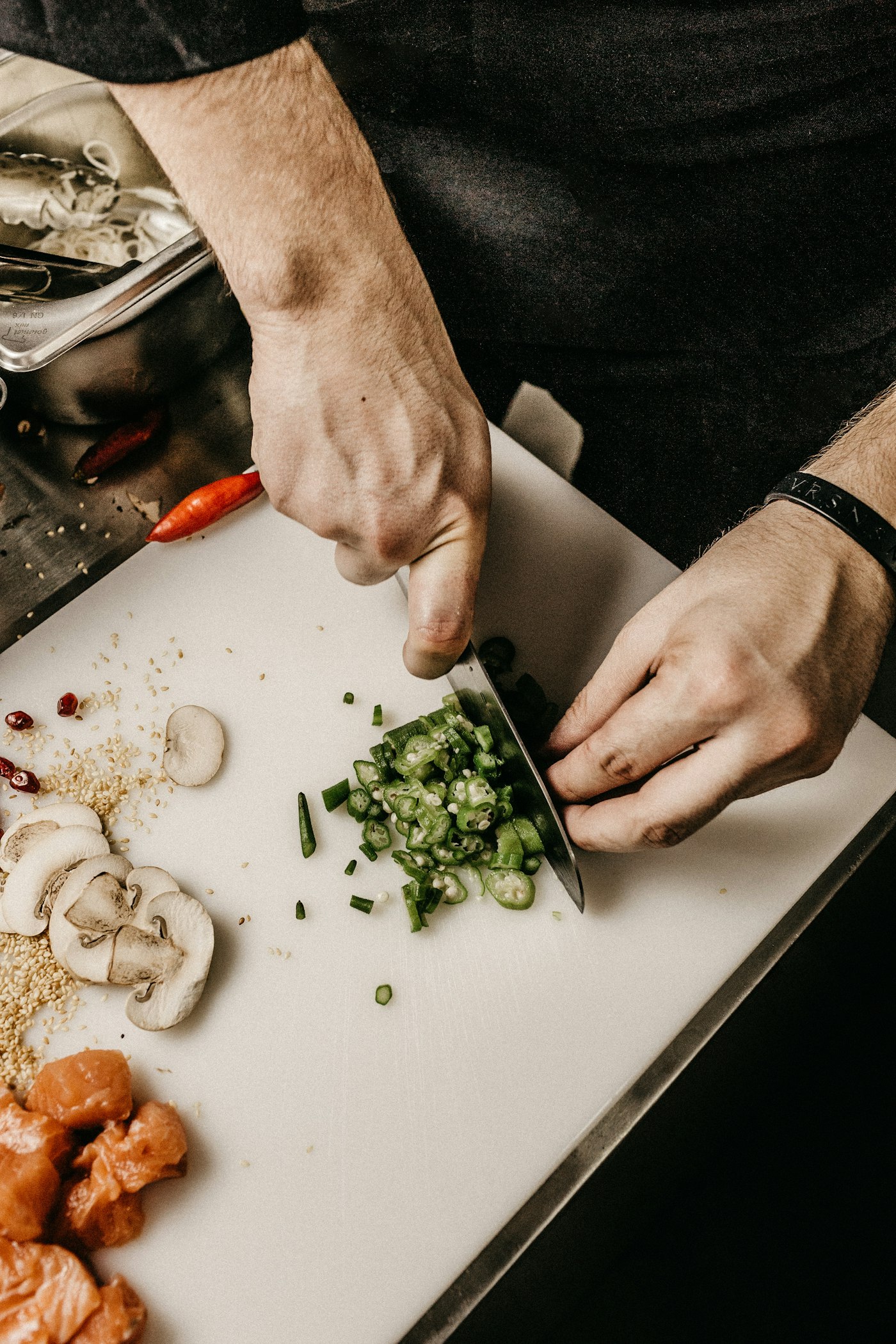 Hands finely chopping herbs on a board