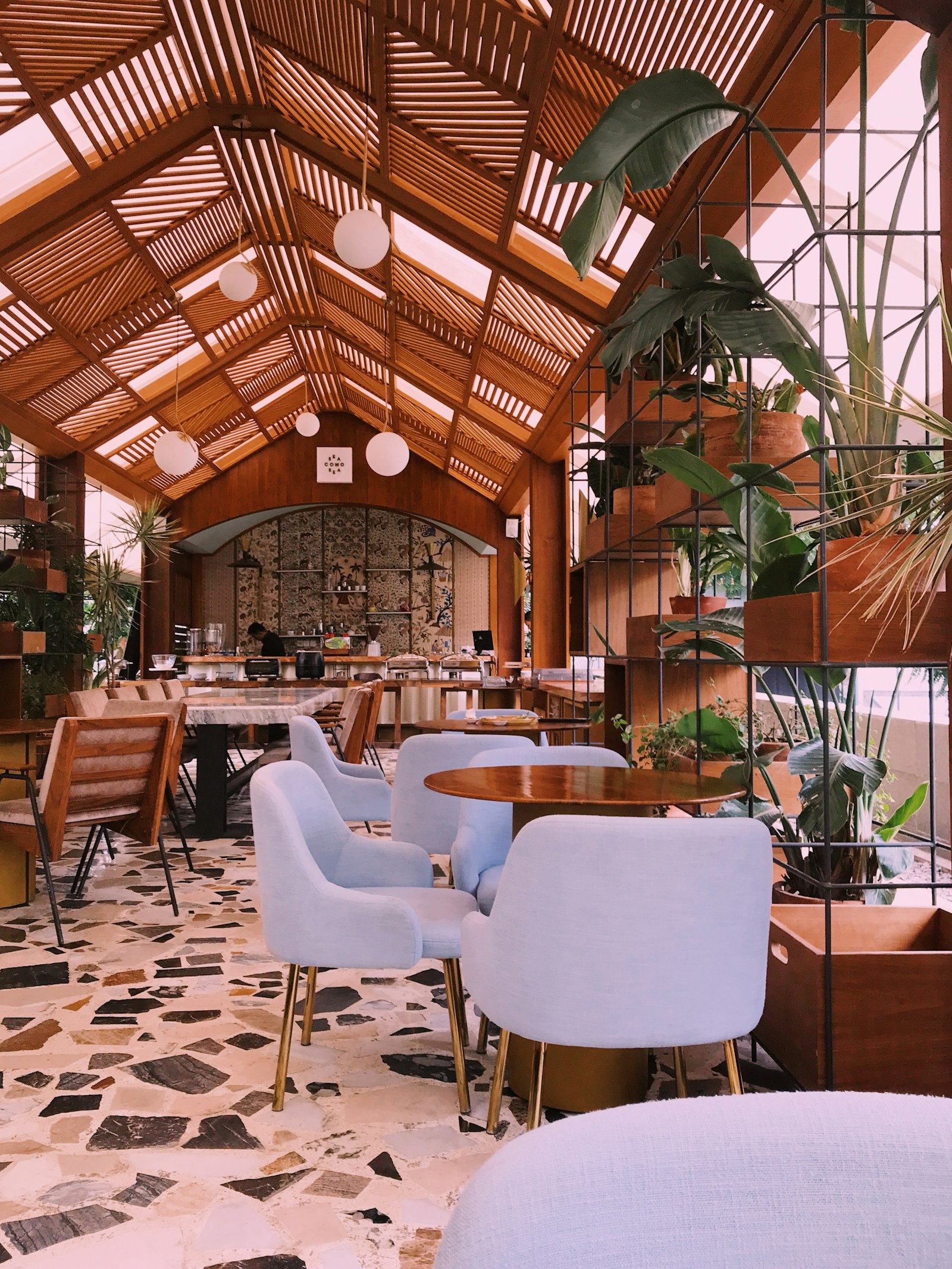 The airy lounge with pale armchairs and timber beams