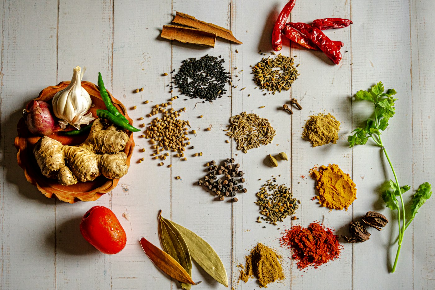 Whole spices laid out on a white surface