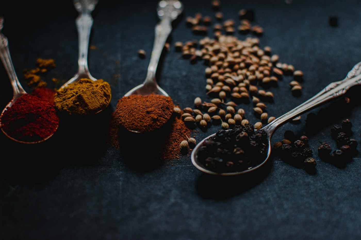Ground spices on wooden spoons